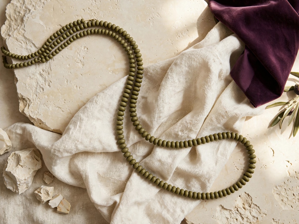 A long green bead strand over linen